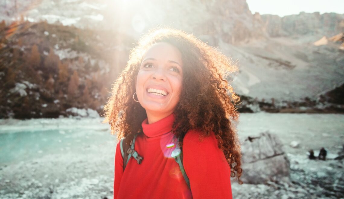 woman wearing red turtle neck shirt near mountain